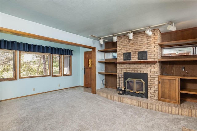 19584 Neills Bluff Rd, Springdale, AR 72764 - unfurnished living room featuring carpet flooring, track lighting, a fireplace, and baseboards