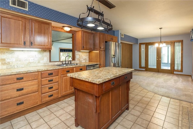 19584 Neills Bluff Rd, Springdale, AR 72764 - kitchen with stainless steel appliances, backsplash, visible vents, a sink, and brown cabinetry