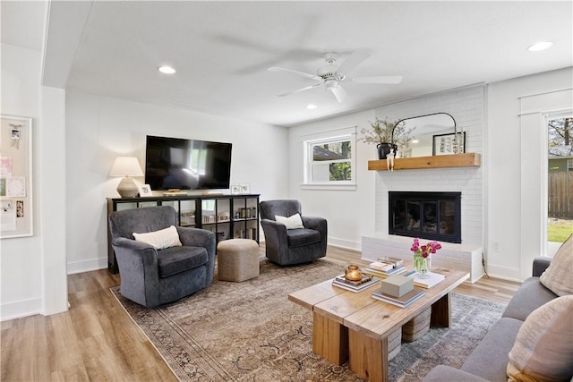 living room with recessed lighting, wood finished floors, a brick fireplace, and ceiling fan