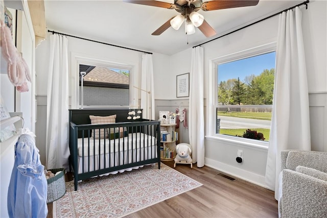 bedroom featuring ceiling fan, baseboards, wood finished floors, and visible vents
