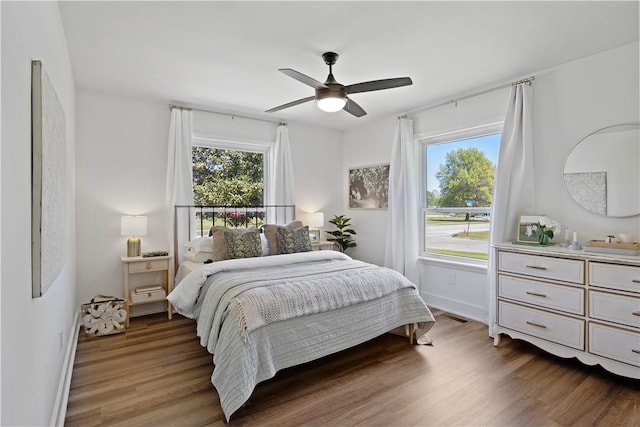bedroom with light wood-style flooring, baseboards, and ceiling fan