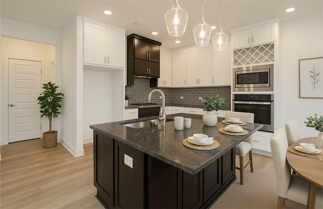 7104 SW High Meadow Blvd, Bentonville, AR 72713 - kitchen with stainless steel appliances, a sink, tasteful backsplash, dark stone countertops, and white cabinets
