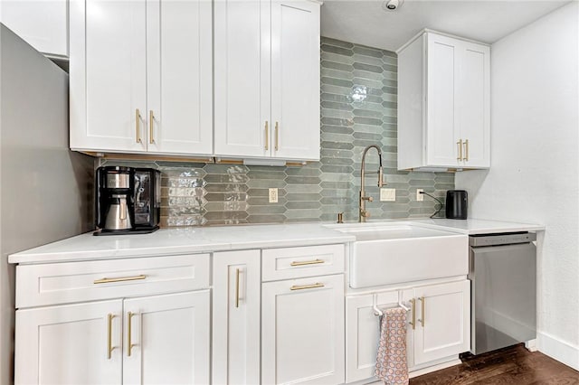 kitchen featuring decorative backsplash, stainless steel appliances, a sink, and white cabinetry