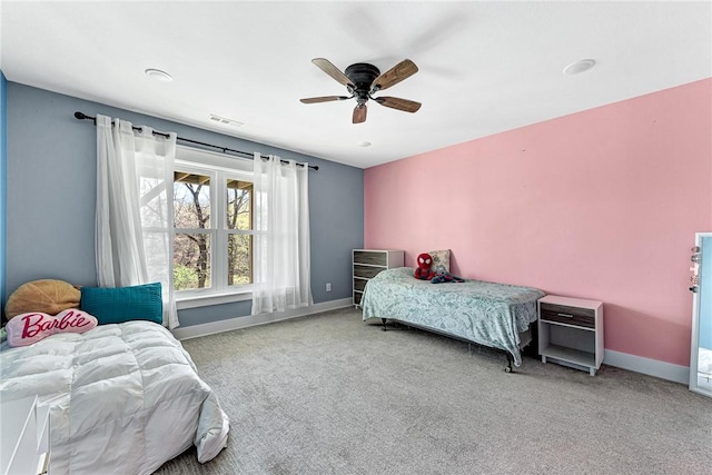 carpeted bedroom featuring baseboards, a ceiling fan, and visible vents