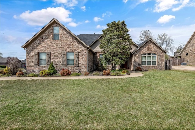 craftsman-style home featuring brick siding, fence, and a front yard