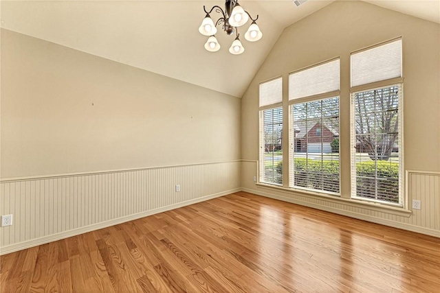 4004 SW Banbury Dr, Bentonville, AR 72713 - spare room featuring wood finished floors, a chandelier, a wainscoted wall, and high vaulted ceiling