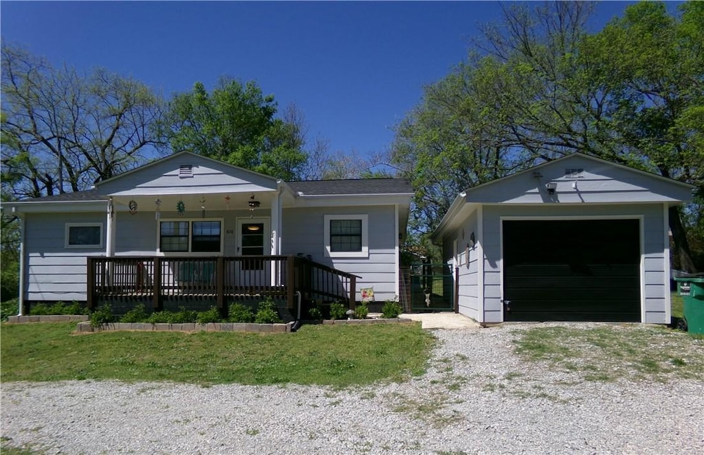 view of front of house featuring driveway, an outdoor structure, covered porch, and a garage