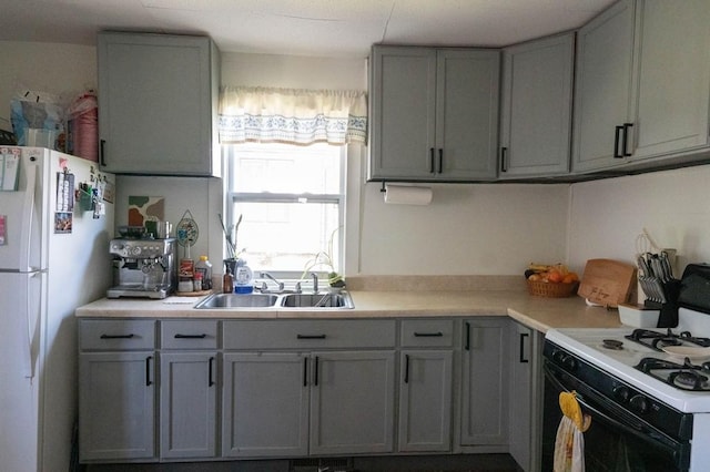 406 N Oak St, Harrison, AR 72601 - kitchen with range with gas cooktop, freestanding refrigerator, gray cabinets, and a sink