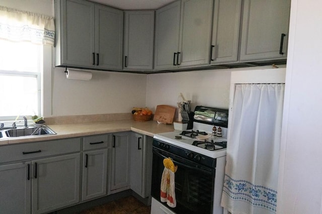 406 N Oak St, Harrison, AR 72601 - kitchen with gray cabinets, gas stove, light countertops, and a sink