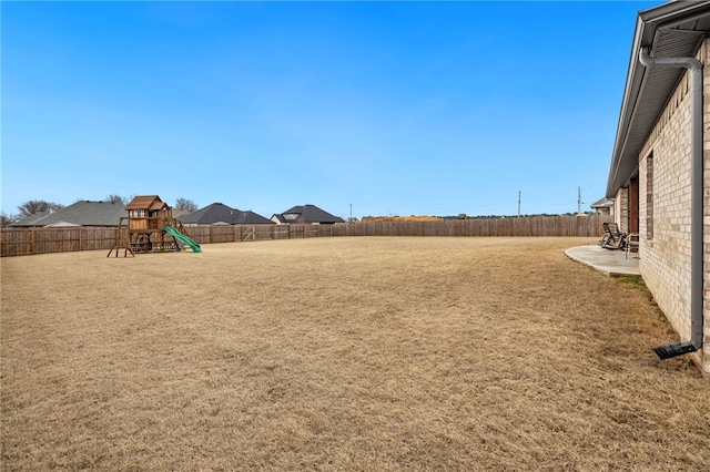 view of yard with a playground and a fenced backyard
