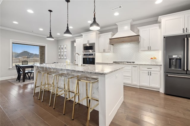 kitchen featuring visible vents, custom range hood, crown molding, and stainless steel appliances