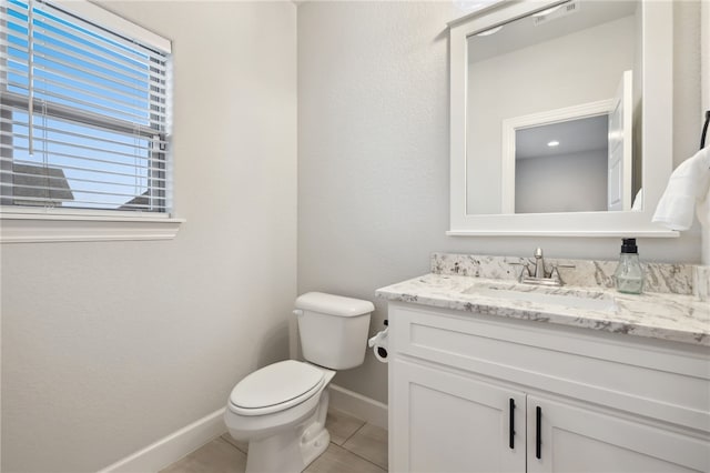half bathroom featuring visible vents, tile patterned flooring, baseboards, vanity, and toilet