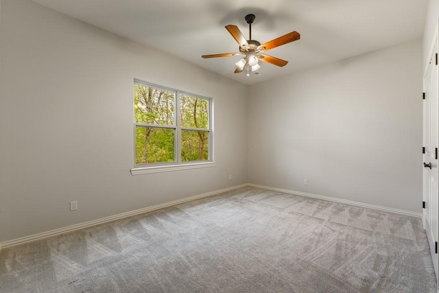 empty room with carpet, baseboards, and a ceiling fan