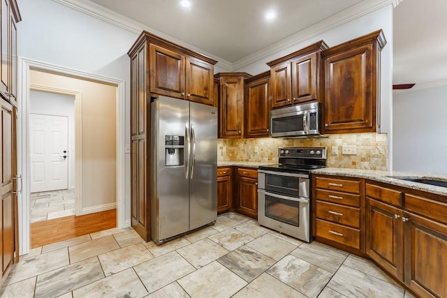 kitchen with appliances with stainless steel finishes, decorative backsplash, light stone counters, and ornamental molding