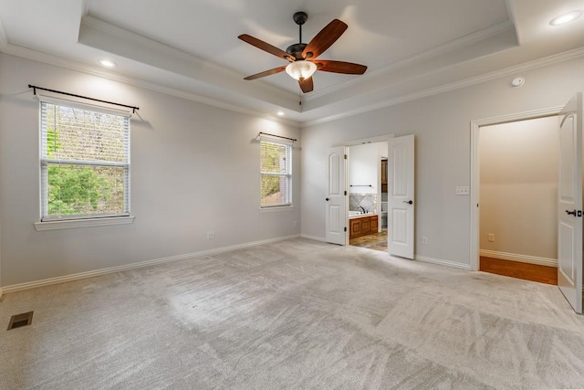 unfurnished bedroom with recessed lighting, visible vents, crown molding, a raised ceiling, and light carpet