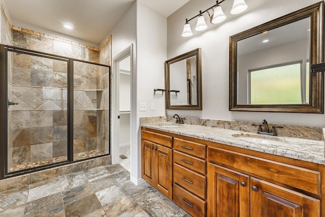 bathroom with a sink, double vanity, a shower stall, and recessed lighting