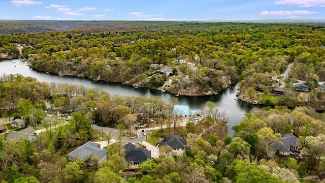 drone / aerial view with a water view and a wooded view