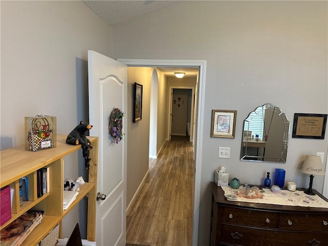 hallway with wood finished floors and baseboards
