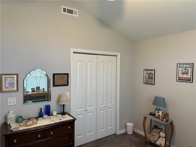 bedroom featuring vaulted ceiling, a closet, baseboards, dark colored carpet, and visible vents