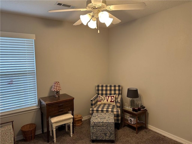 living area featuring carpet flooring, visible vents, a ceiling fan, and baseboards