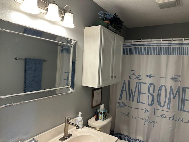 bathroom featuring visible vents, a sink, a shower with shower curtain, and toilet
