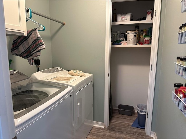 washroom with baseboards, washer and clothes dryer, dark wood finished floors, and cabinet space