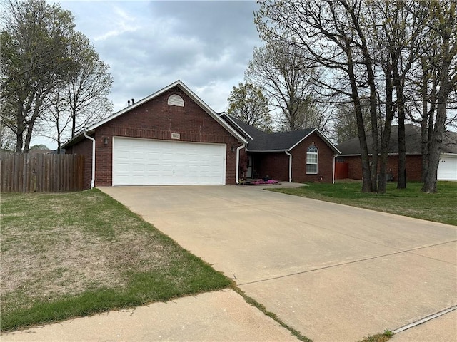 ranch-style home with fence, driveway, brick siding, a front yard, and a garage