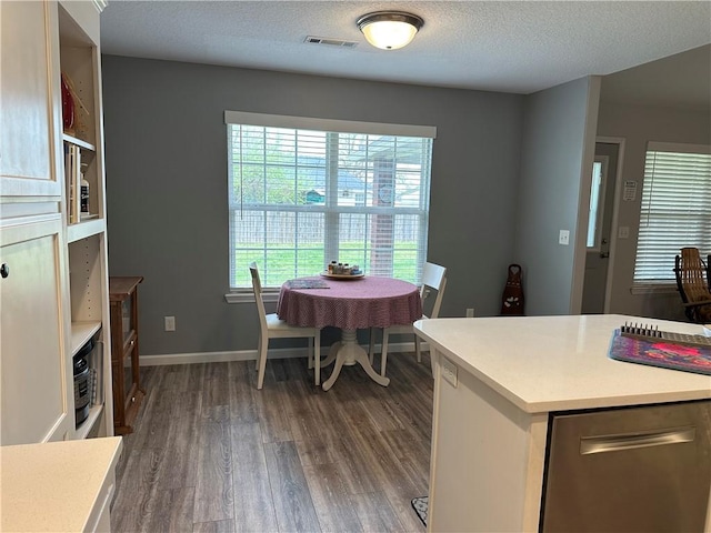 dining area with visible vents, baseboards, dark wood-style floors, and a textured ceiling