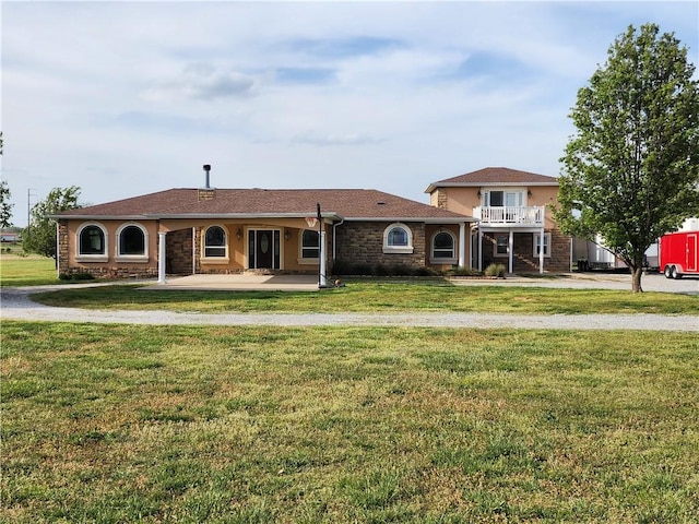 view of front of house featuring a front lawn and a balcony