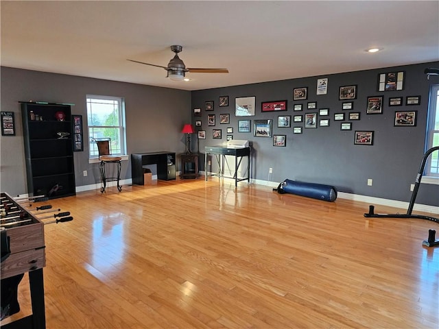 interior space with wood finished floors, baseboards, and ceiling fan