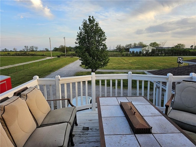 wooden deck with a rural view and a lawn