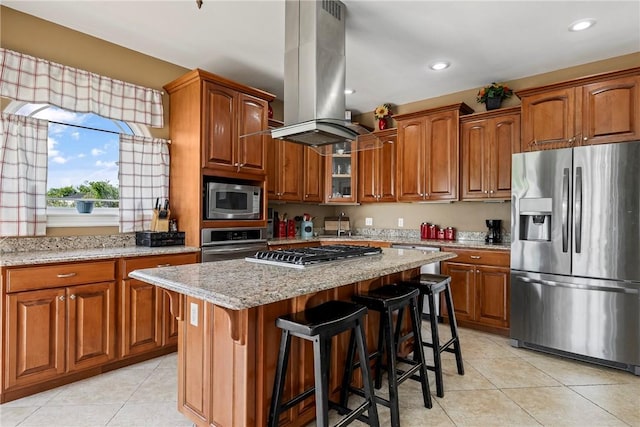 21854 S Floyd Moore Rd, Gentry, AR 72734 - kitchen featuring appliances with stainless steel finishes, island range hood, light tile patterned floors, brown cabinets, and recessed lighting