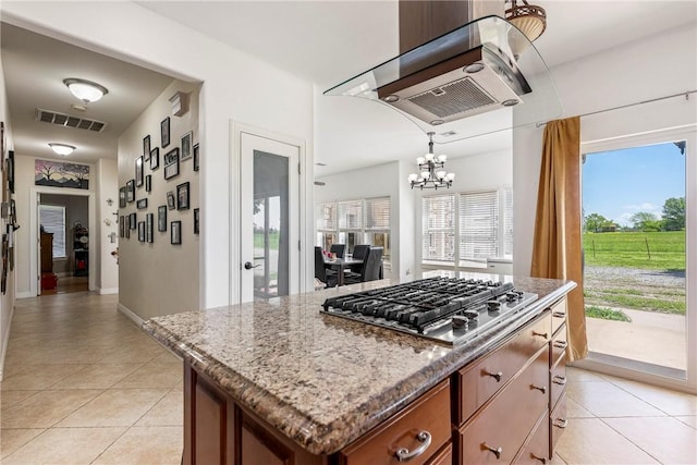 21854 S Floyd Moore Rd, Gentry, AR 72734 - kitchen with stainless steel gas stovetop, a chandelier, light tile patterned floors, brown cabinetry, and plenty of natural light