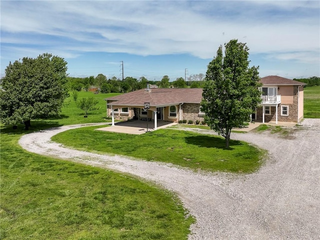 21854 S Floyd Moore Rd, Gentry, AR 72734 - rear view of house featuring curved driveway, a lawn, a patio area, a balcony, and stone siding