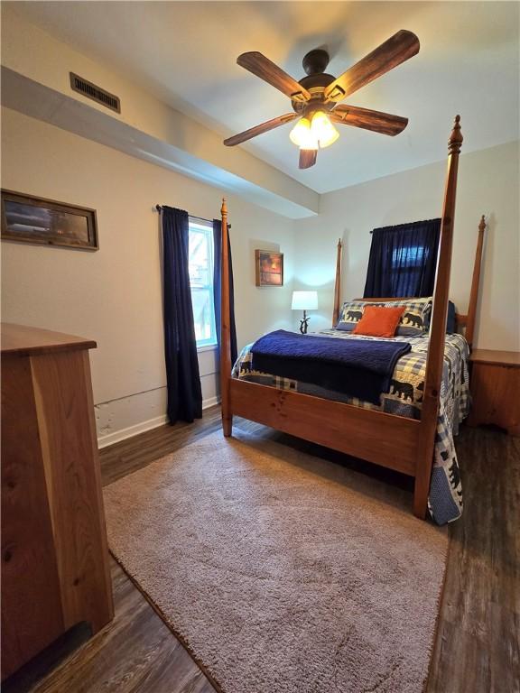 bedroom featuring ceiling fan, baseboards, wood finished floors, and visible vents