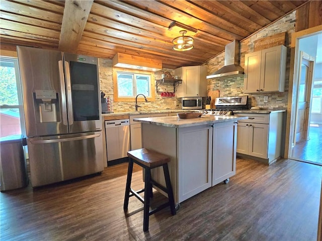 kitchen with wooden ceiling, wall chimney exhaust hood, appliances with stainless steel finishes, and a healthy amount of sunlight