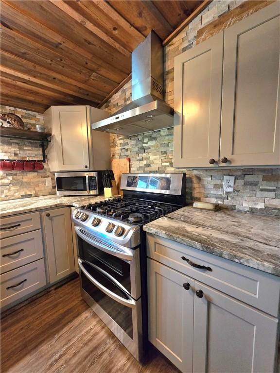 kitchen featuring stainless steel appliances, tasteful backsplash, wall chimney range hood, wooden ceiling, and dark wood-type flooring