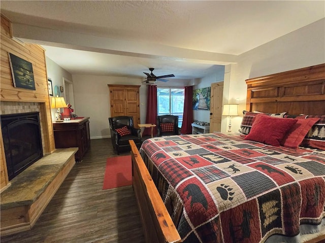 bedroom featuring ceiling fan, baseboards, a large fireplace, and dark wood-type flooring