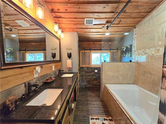 full bath with wood ceiling, tiled tub, visible vents, and a sink