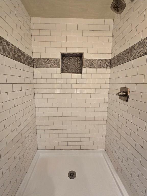 full bath featuring tiled shower