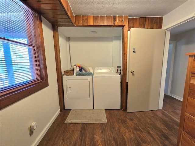 clothes washing area with washing machine and clothes dryer, dark wood-type flooring, laundry area, and baseboards