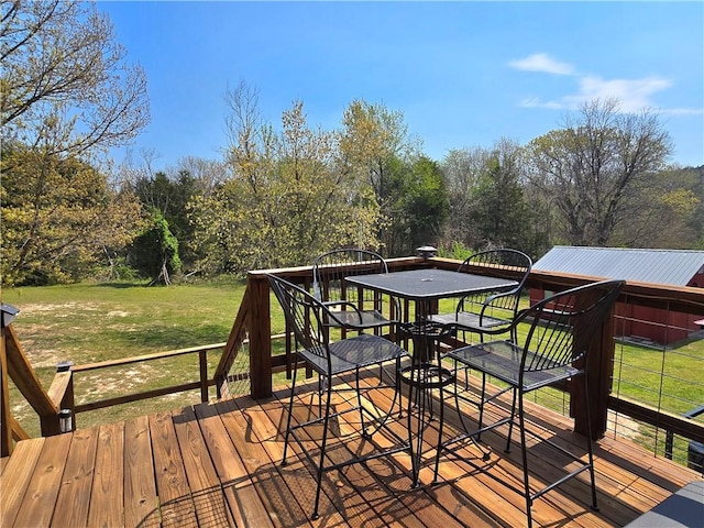 wooden terrace with a yard and outdoor dining area