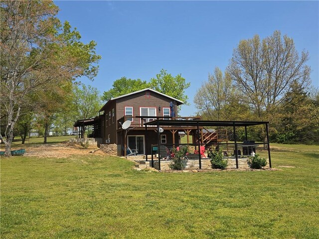 rear view of house with a wooden deck, a yard, and a patio