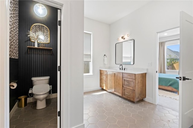 bathroom with baseboards, vanity, toilet, and tile patterned flooring