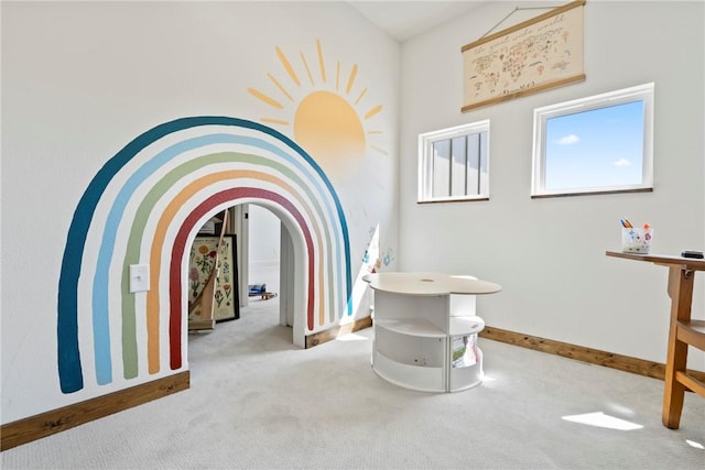 corridor with carpet floors, baseboards, and arched walkways