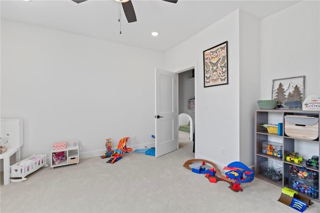 recreation room with a ceiling fan, carpet, and baseboards