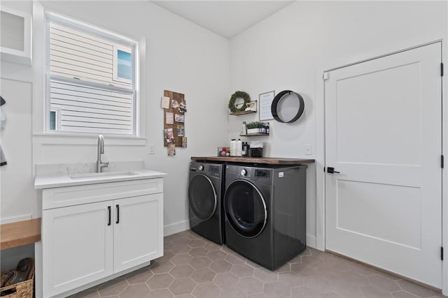 laundry room featuring separate washer and dryer, light tile patterned floors, cabinet space, and baseboards
