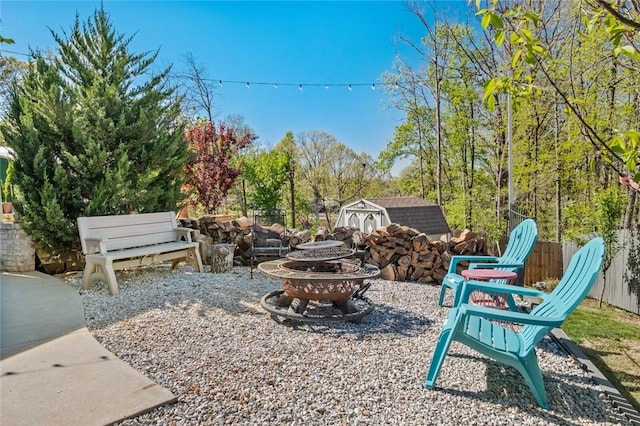view of patio / terrace with a fire pit, an outdoor structure, and a shed