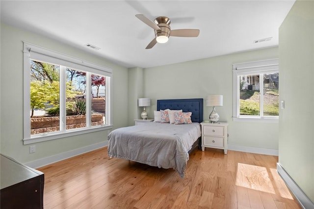 bedroom with wood finished floors, multiple windows, and visible vents