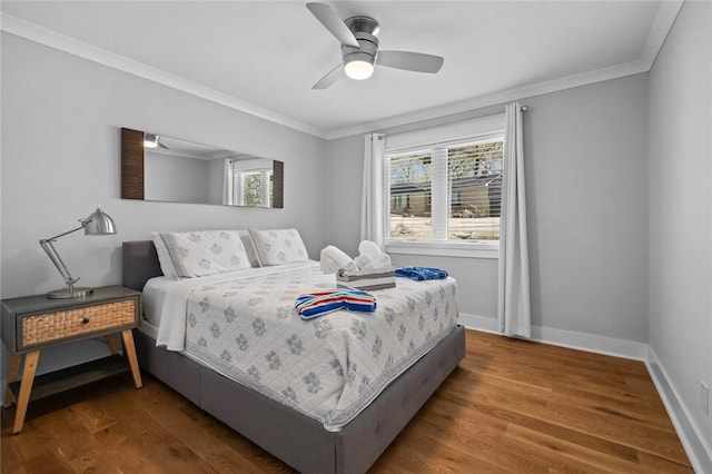 bedroom featuring ceiling fan, baseboards, crown molding, and wood finished floors